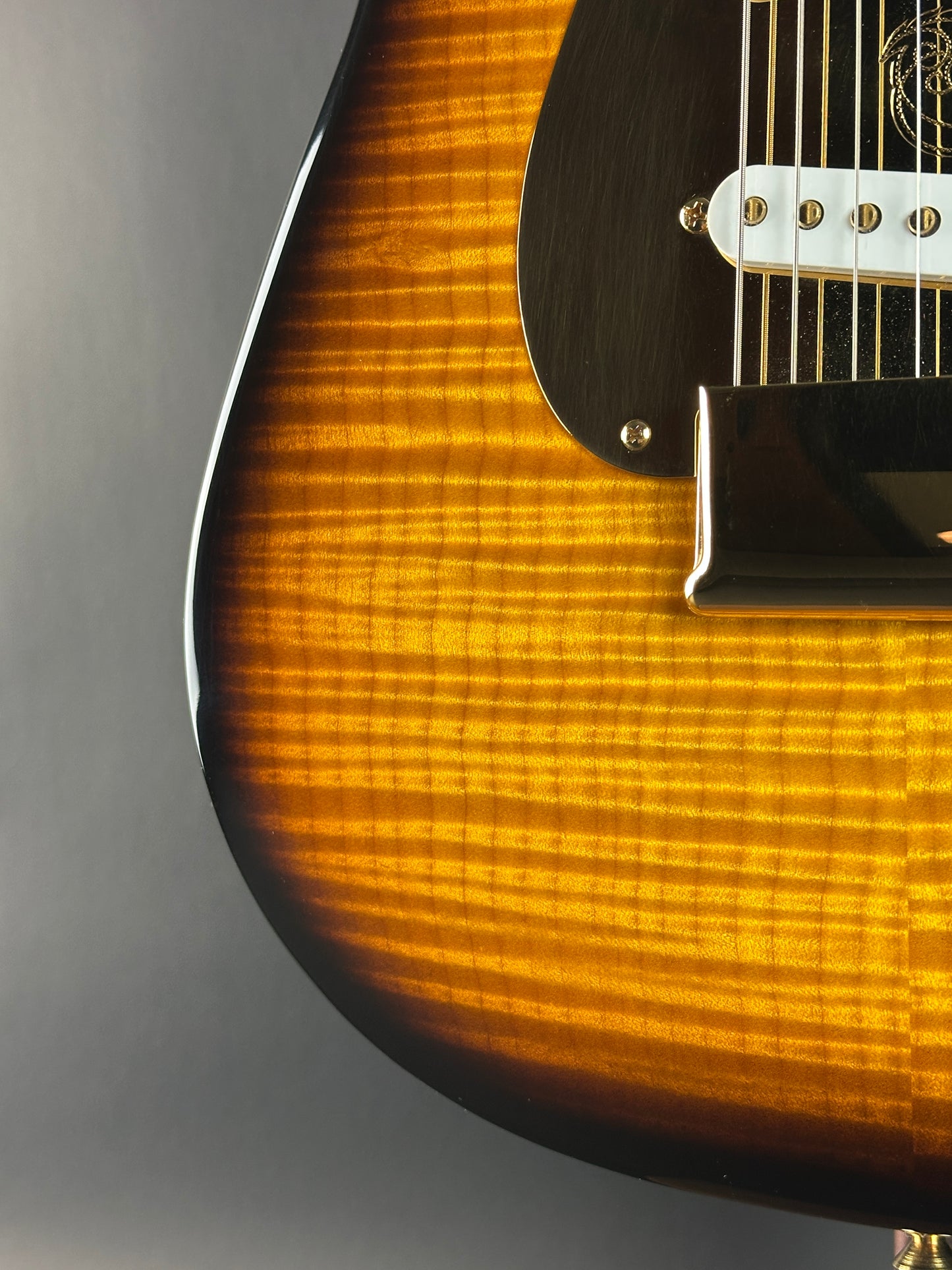 Close-up of a guitar's body with a focus on the wood grain and finish.