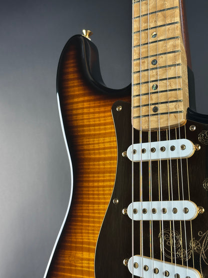 Close-up of a guitar's neck and body on a gray background