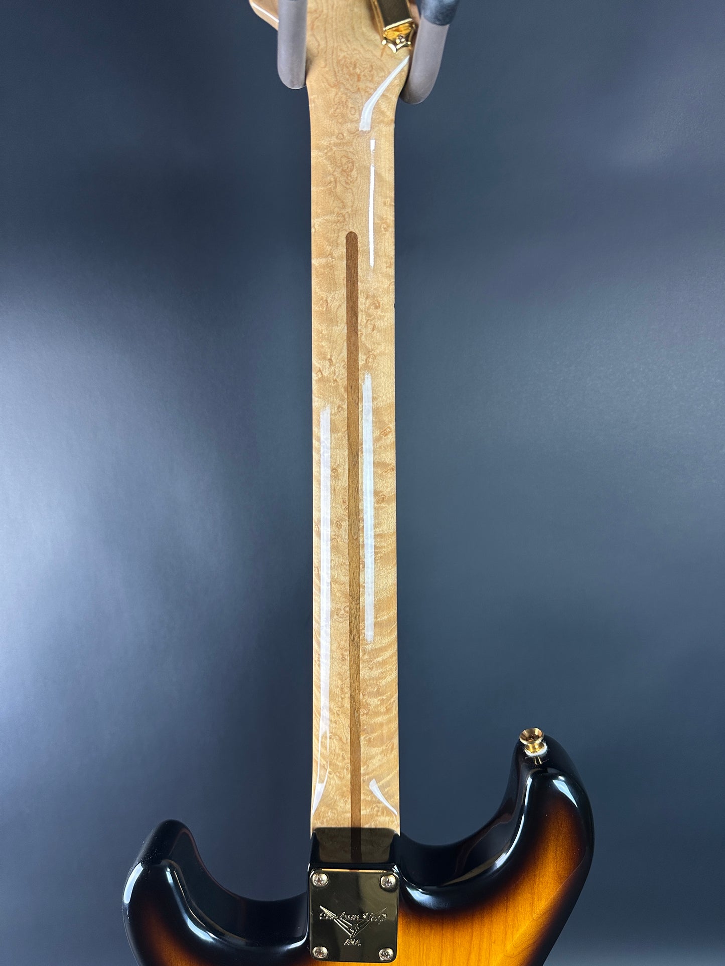 Close-up of a guitar neck with a dark background