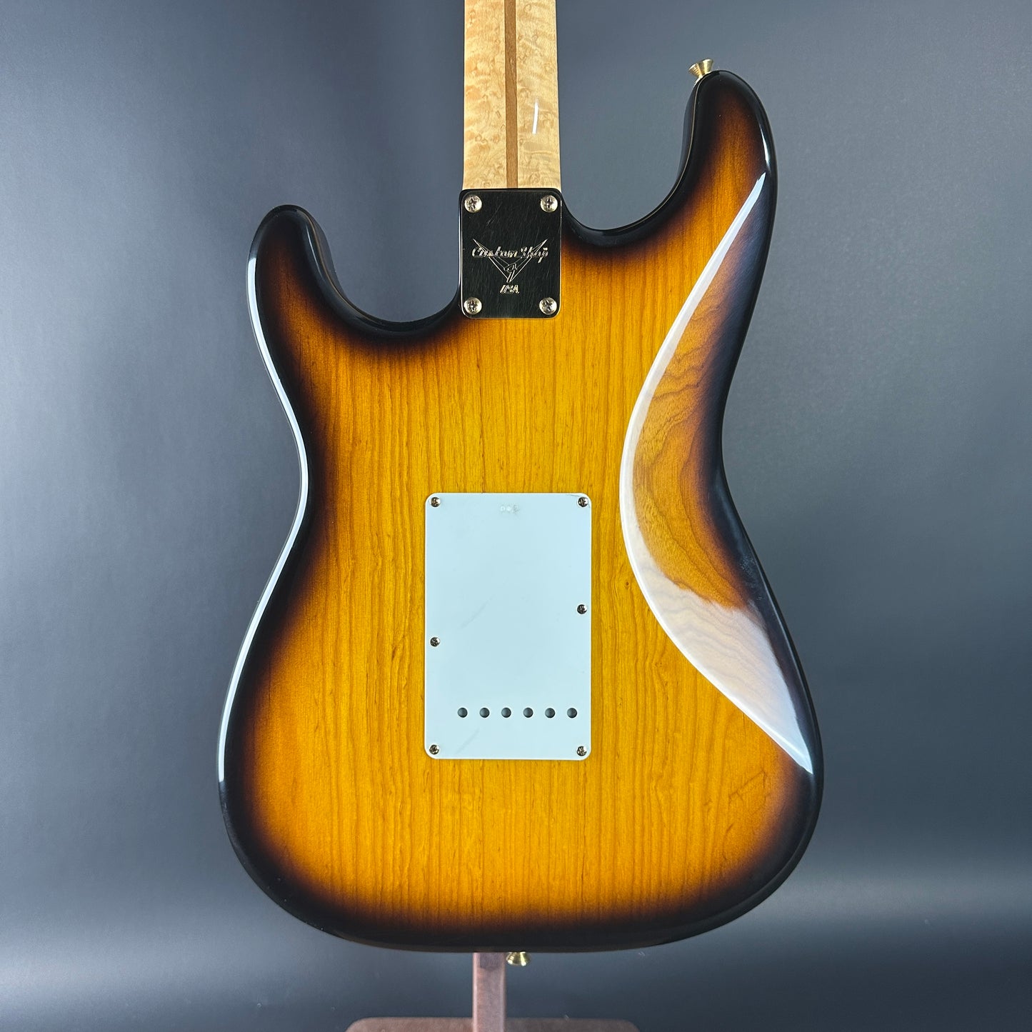 Wooden electric guitar with a gradient finish on a gray background