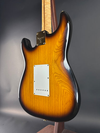 Close-up of a guitar body with a gradient finish on a gray background