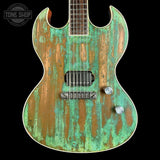Distressed green and brown electric guitar on a black background with 'Tone Shop' logo.