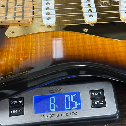 Guitar on a digital scale displaying weight