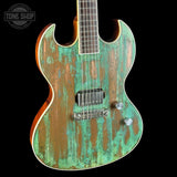 Distressed green and brown electric guitar on a black background with 'Tone Shop' logo.