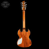 Wooden guitar with a white pickguard on a black background, featuring the Tone Shop logo.