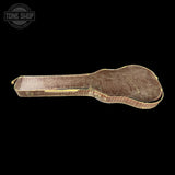 Vintage guitar case with a textured surface on a black background, featuring 'Tone Shop' branding.