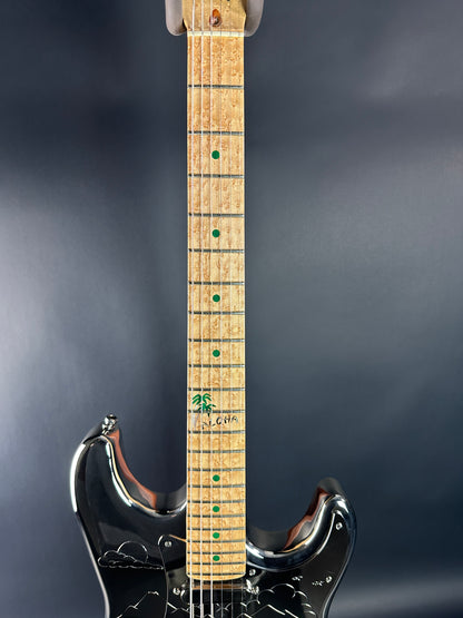 Electric guitar neck with brand logo on a dark background