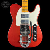 A red Telecaster-style electric guitar with a cream pickguard, maple neck, black control plate, and silver tremolo hardware, photographed against a black background. A Tone Shop watermark is visible in the top-left corner.
