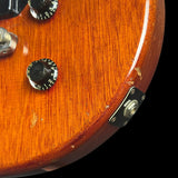 Close-up of a guitar's wood grain and control knobs on a black background