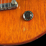 Close-up of a guitar's wood finish with a control knob