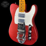 A red electric guitar with a white pickguard, maple neck, and chrome hardware, shown against a black background with a Tone Shop watermark in the top left corner.