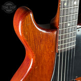 Close-up of a guitar neck and headstock with a dark background