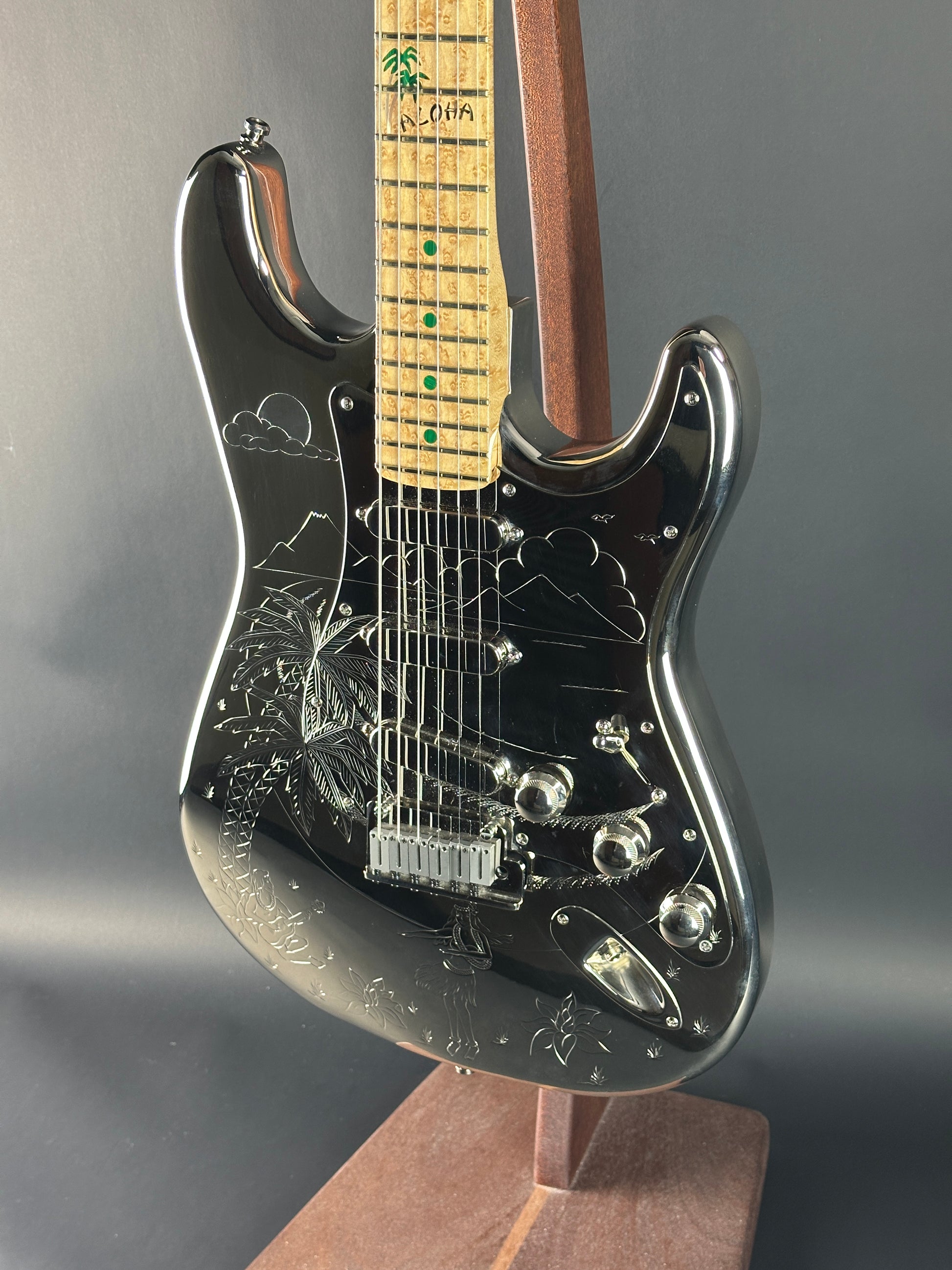 Close-up of a black electric guitar with a gray background