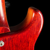 Close-up of a red electric guitar's body with a black background