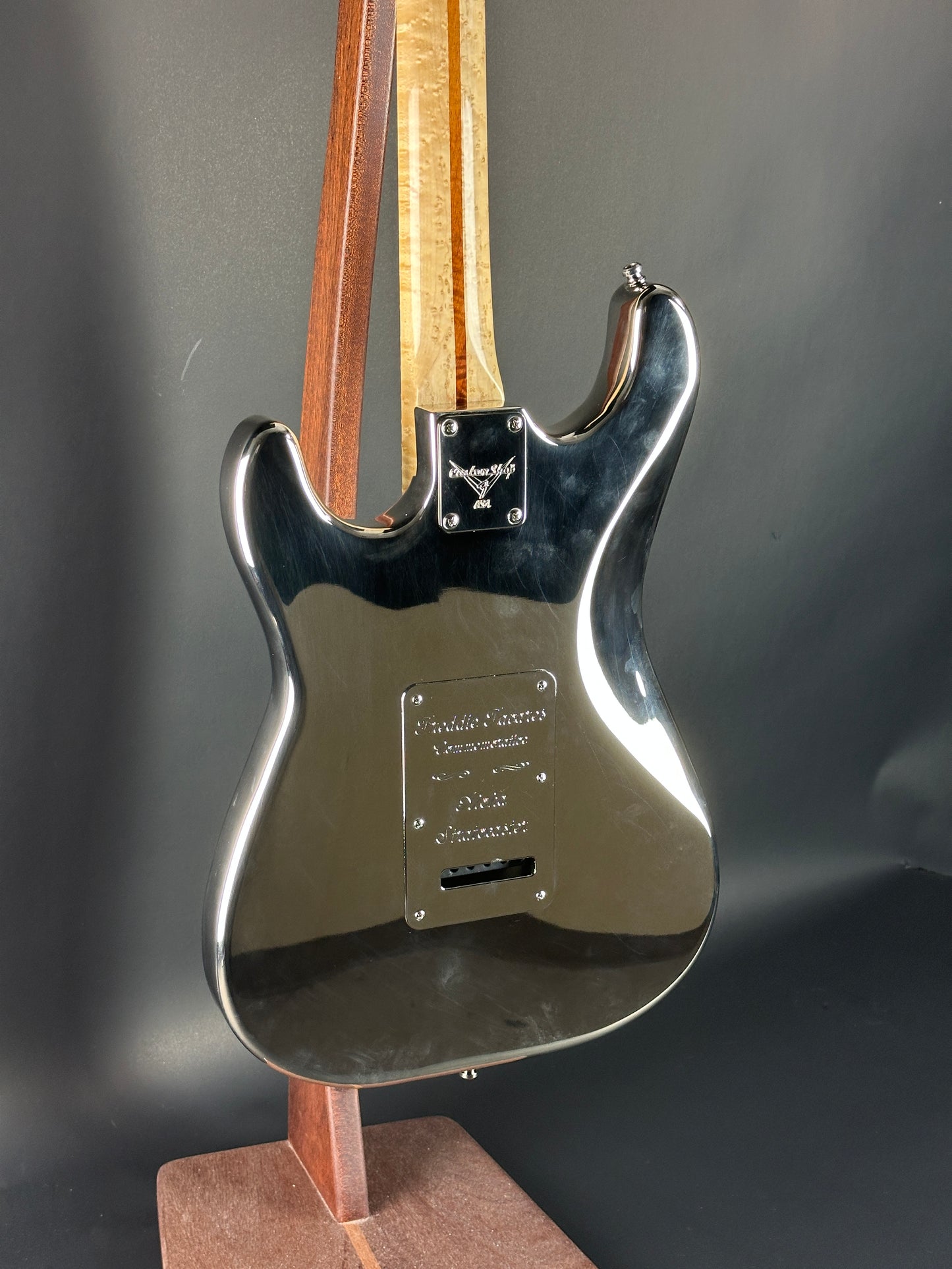Close-up of a guitar's neck and headstock on a dark background