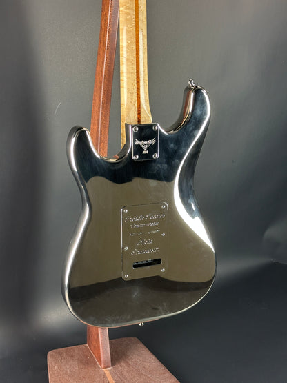 Close-up of a guitar's neck and headstock on a dark background