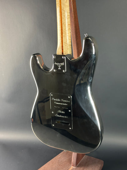 Close-up of a guitar headstock with brand name on a gray background