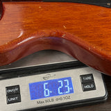 Wooden object being weighed on a digital scale with a digital display showing weight.