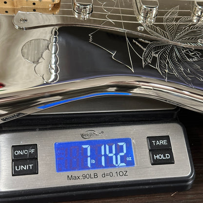 Digital scale with a cannabis leaf design on the platform, displaying weight.