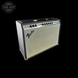 A Fender guitar amplifier with a black textured cabinet, cream-colored grille, and a row of black control knobs on the top front panel, shown against a solid black background.
