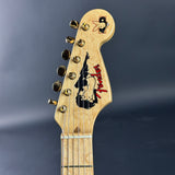 Guitar headstock with Fender logo on a dark background
