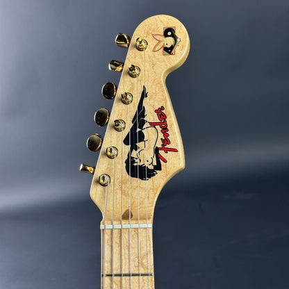 Guitar headstock with Fender logo on a dark background