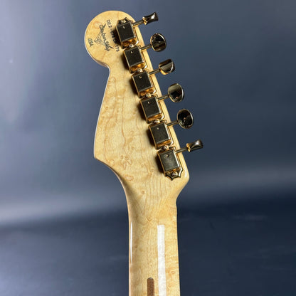 Guitar headstock with tuning pegs on a dark blue background