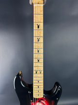 Electric guitar with a red pickguard on a gray background