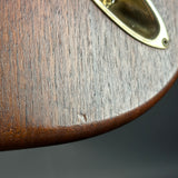 Close-up of a wooden surface with a brass handle on a dark background