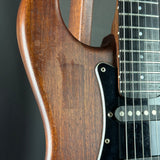 Close-up of a guitar's wooden body and neck on a dark background