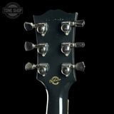 Gibson guitar headstock with tuning pegs on a black background