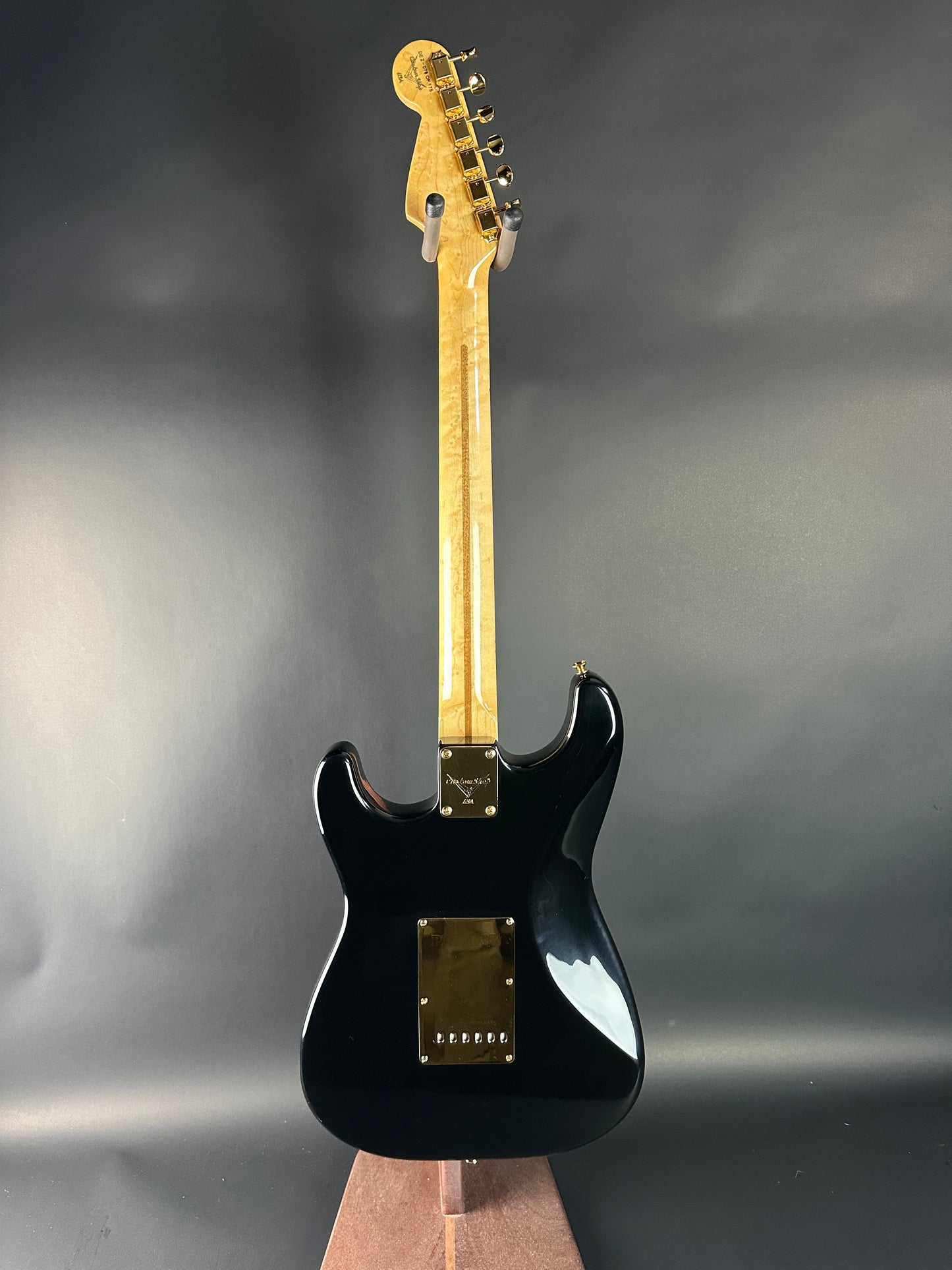 Black electric guitar on a gray background