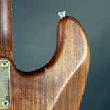 Close-up of a wooden guitar neck with a dark gray background