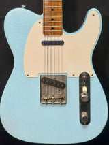 Light blue electric guitar with a white pickguard on a black background