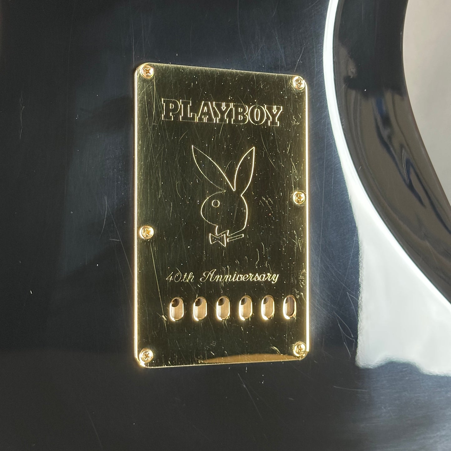 Gold Playboy plaque with rabbit logo on a dark surface