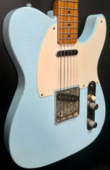 Light blue electric guitar with a white pickguard on a black background