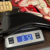 Guitar on a digital scale displaying weight