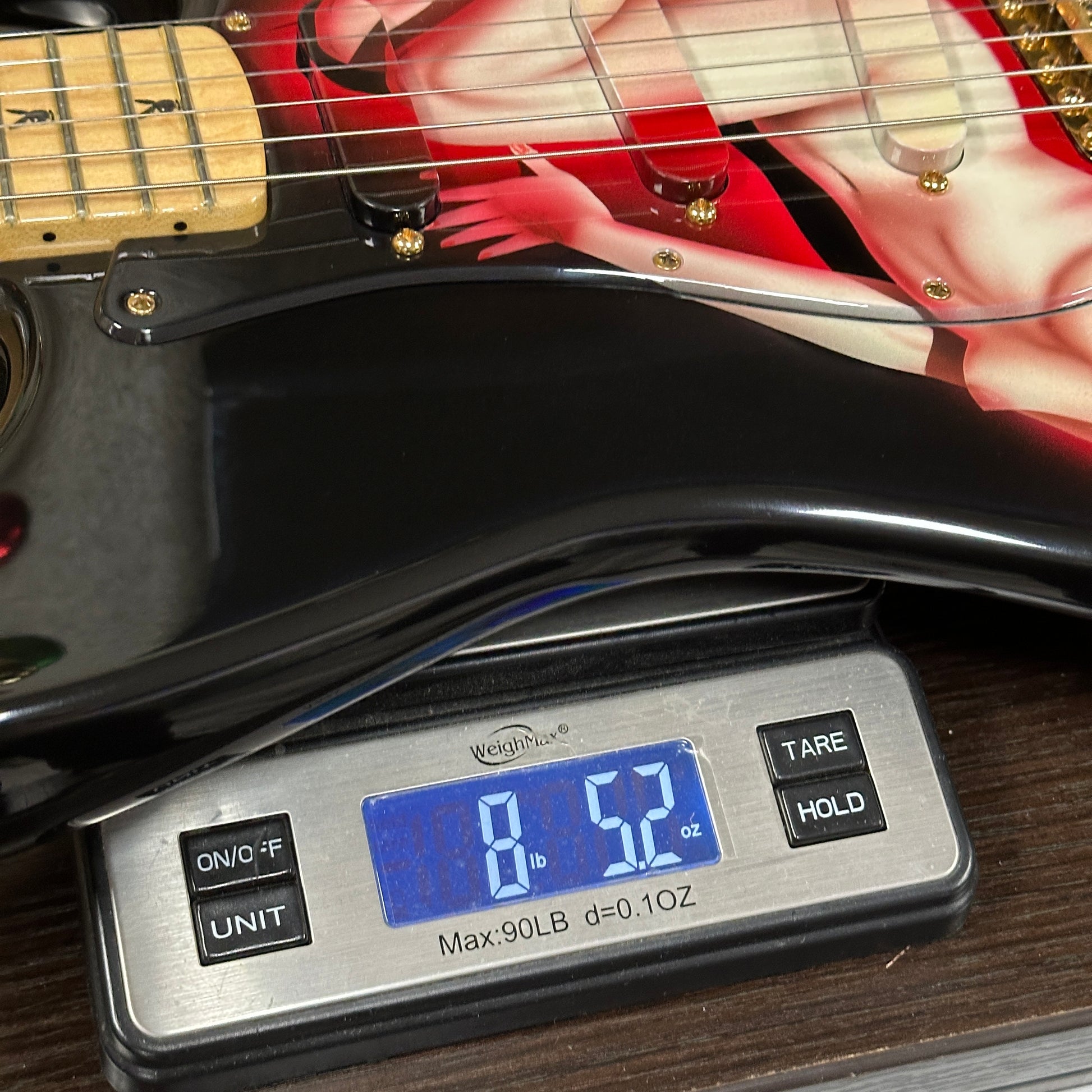 Guitar on a digital scale displaying weight