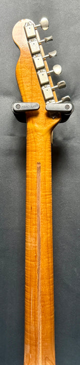 Close-up of a guitar neck with headstock on a gray background