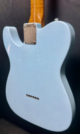 Light blue electric guitar body with a wooden neck on a dark background
