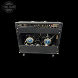 A black guitar amplifier head with its front panel removed to show the internal speaker wiring and components, set against a solid black background. A Tone Shop watermark is visible in the top-left corner.