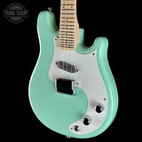 Turquoise electric guitar with a visible brand logo on a black background