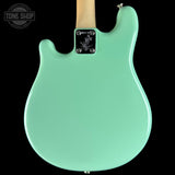 Green electric guitar with a visible brand logo on a black background