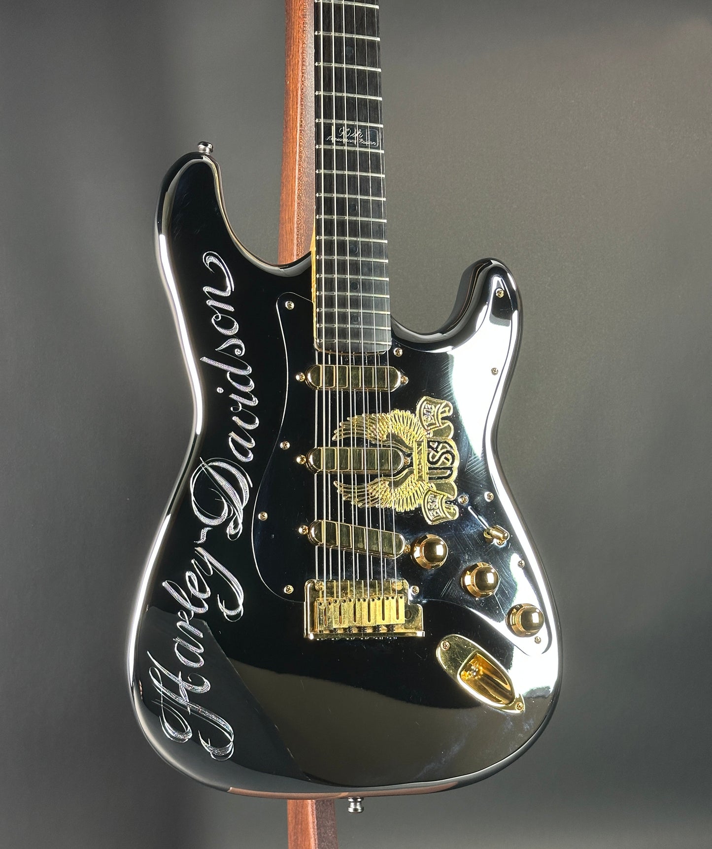 Black electric guitar with gold details on a gray background