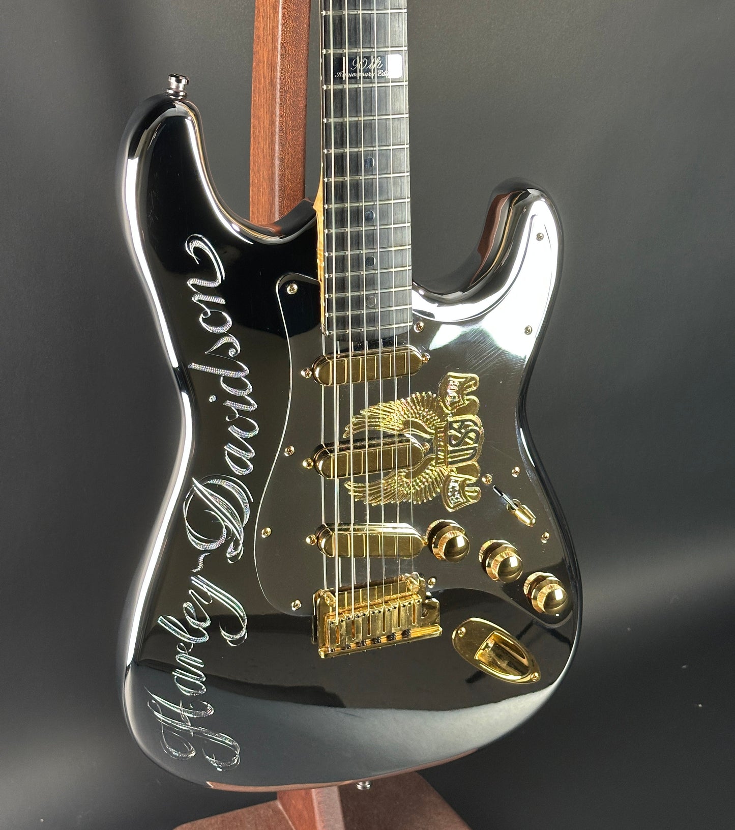 Black electric guitar with gold hardware on a dark background