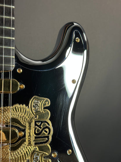 Close-up of a guitar's headstock with brand logo on a dark background