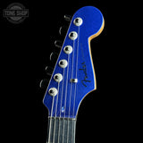 Close-up of a blue guitar headstock with 'Fender' branding on a black background.