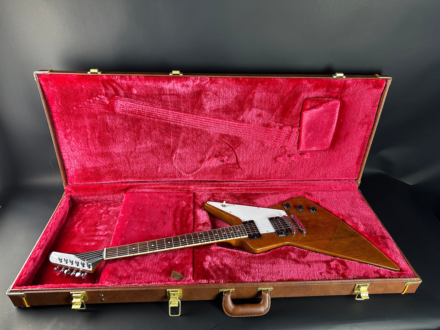 Guitar in a red-lined case on a dark background