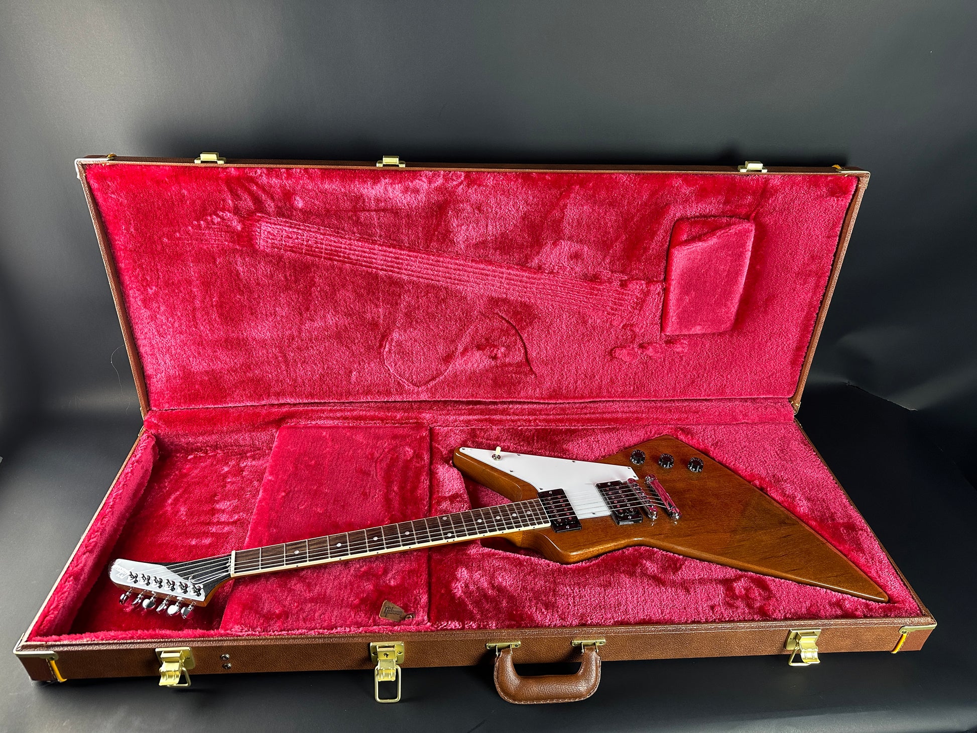 Guitar in a red-lined case on a dark background
