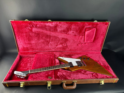 Guitar in a red-lined case on a dark background